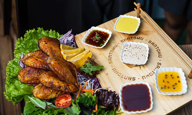 Alitas x8 unidades + papas amarillas fritas en  Santoku Sushi Bar local a elección.