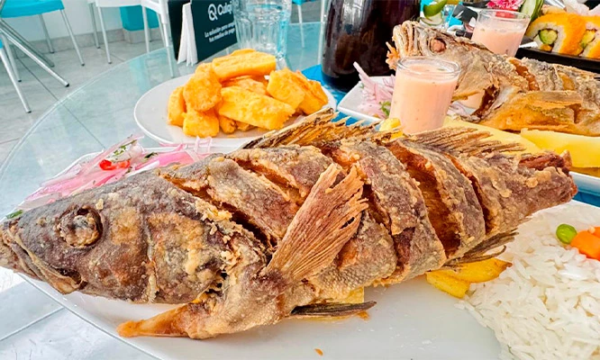 Pescado entero frito + arroz + papa dorada + zarza criolla en Restaurante Cevicheria Tacu Mar