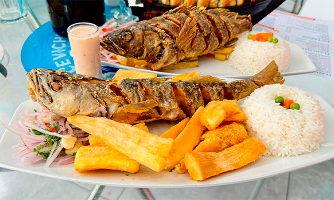 Pescado entero frito + arroz + papa dorada + zarza criolla en Restaurante Cevicheria Tacu Mar